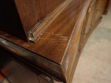 a close up of a wooden dresser with a drawer underneath it
