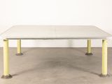 an image of a white table with yellow legs in a room