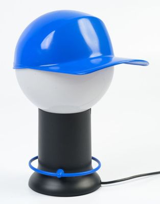 a blue and white baseball cap on top of a lamp