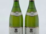 deux bouteilles de vin posées sur une table l'une à côté de l'autre
