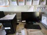 un bureau sur lequel se trouvent un ordinateur, un écran, un clavier et des papiers