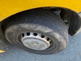a close up of a tire on the side of a yellow car