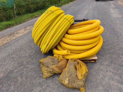 un tas de tuyaux jaunes posés sur le bord de la route