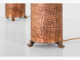a pair of copper lamps on a white surface