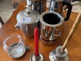 une table en bois sur laquelle sont posées des cafetières et des tasses en argent