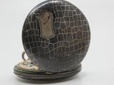 a black pocket watch with a brown face on it