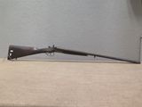 un vieux fusil posé sur une table près du mur