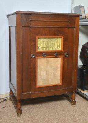 une vieille radio posée sur une table à côté d'un vase