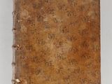 an old book sitting on top of a table next to a white wall