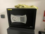 a small black safe box on top of a black filing cabinet