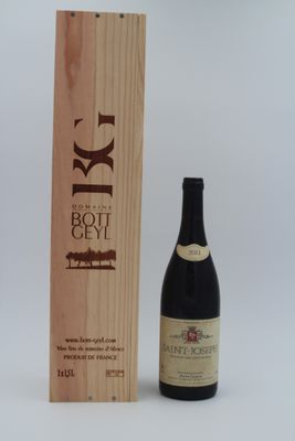 une bouteille de vin posée à côté d'une caisse en bois
