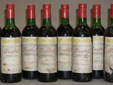 six bouteilles de vin sont alignées sur une table
