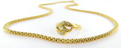 an image of a gold necklace and ring set on a white background