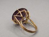 a close up of a gold ring with a purple stone
