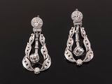 a pair of diamond and white gold earrings