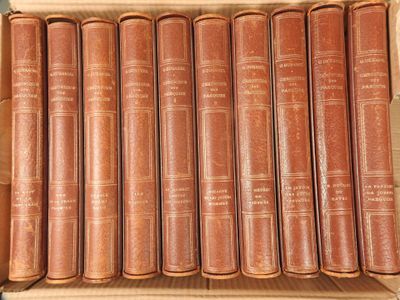 six old books in a cardboard box on a table