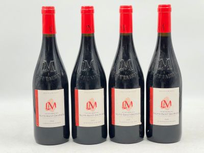 trois bouteilles de vin rouge posées l'une à côté de l'autre sur une surface blanche