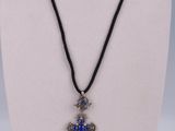 a necklace with a blue cross on a black cord