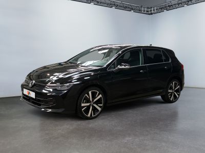 Une Volkswagen e-Golf noire est garée dans une pièce blanche