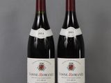 two bottles of wine sitting on top of a table next to each other