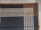 a close up of a blue and brown striped scarf on a table