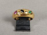 un gros plan d'une bague en or ornée de pierres multicolores
