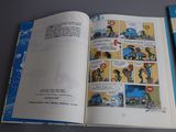 a comic book open on a table next to a computer mouse