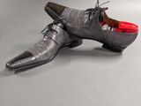men ' s gray leather shoes with red soles on a grey background