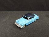 a blue toy car with a black roof on a black surface