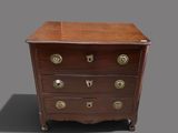 an antique chest of drawers on casteors with brass handles