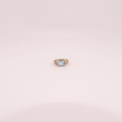 une image d'une bague en or avec une pierre en topaze bleue