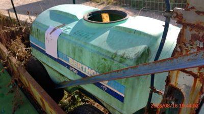 a green tank that is sitting in the dirt