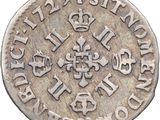 a close up of a silver coin with a cross on it