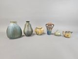 many different vases and cups sitting on a white surface