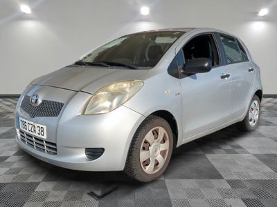 une photo d'une toyota yaris argentée garée sur un sol en damier