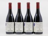 trois bouteilles de vin rouge sont alignées sur une surface blanche