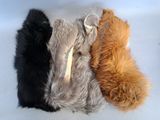 four different colored furs are laid out on a white surface