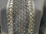 an image of a mannequin wearing a black dress with silver beads on it