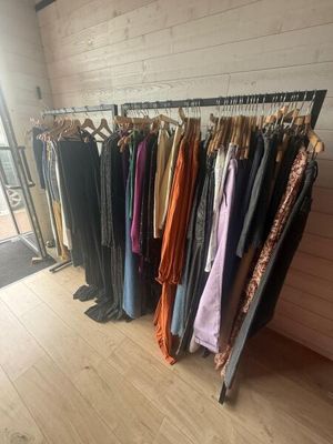 clothes hanging on a rack in front of a window in a room