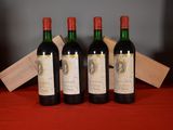 three bottles of red wine sit on a table next to a wooden box