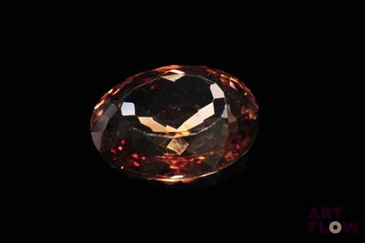 a close up view of a large orange diamond on a black background