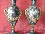 paire de vases anciens noirs et dorés sur fond rouge