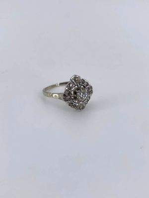 a close up of a diamond ring on a white surface
