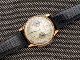 un gros plan d'une montre avec un bracelet noir posée sur une table
