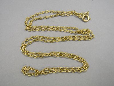 a close up of a gold chain on a gray surface