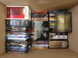 a cardboard box filled with many dvds and movies