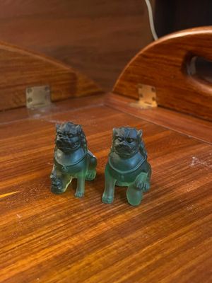 two figurines of two dogs sitting on a table