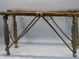 une petite table en bois sur laquelle se trouve un tas de bâtons