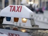 un panneau « taxi » posé sur le toit d'une voiture dans une rue de la ville