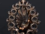 a close up of a silver pendant on a black surface
